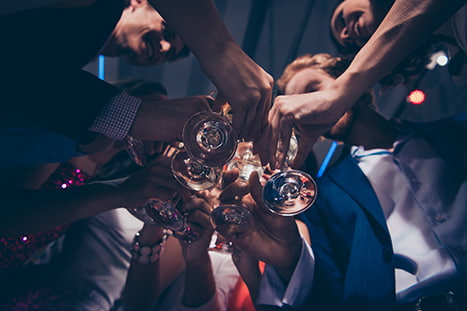 A low angle perspective of a group of friends toasting glasses of champagne