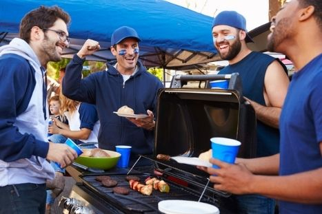 sports fans celebrating at a tailgate barbecue