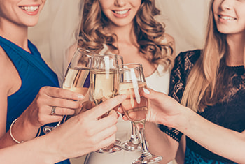 A bride and her friends toast champagne at a bachelorette party